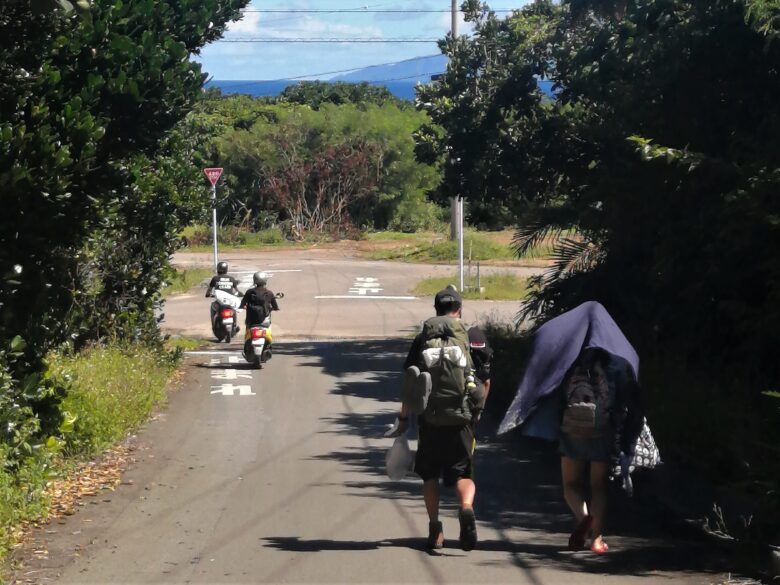 波照間島の道を歩く2人とバイク2台