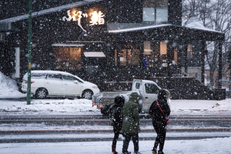 ニセコの街を雪の中歩く人たち