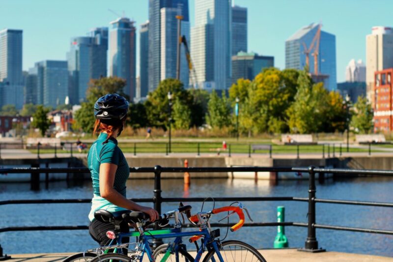 モントリオールの建物を眺めるサイクリングしている女性