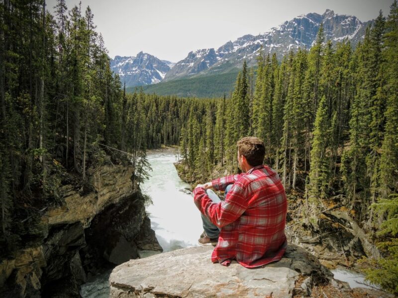 カナダのロッキー山脈を見ている男性